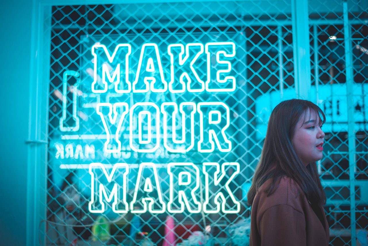 What signs are excluded from being trade marks. Woman standing infront of a sign that says "make your mark".