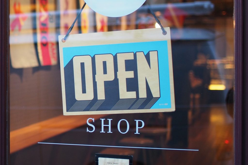 Picture of a sign on a shop that says open. Demonstrates "trademark the name of a business"