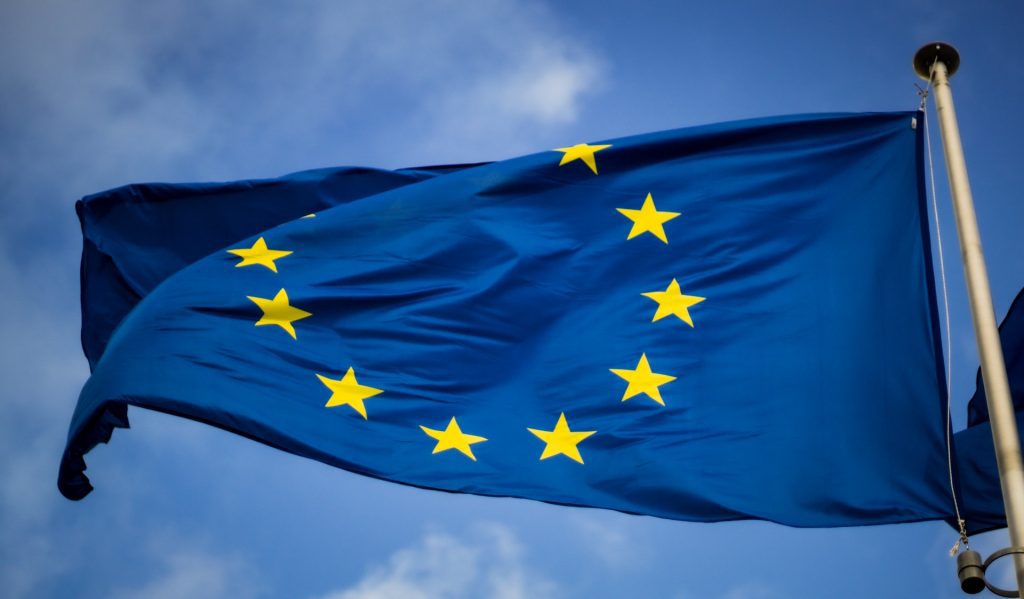 The impact of Brexit on UK intellectual property law - image of an EU flag flying in the wind with a blue sky in the background