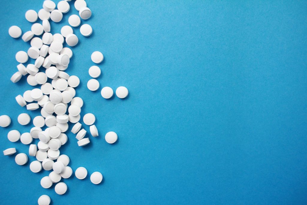Image of a spread of white pills on a blue background
