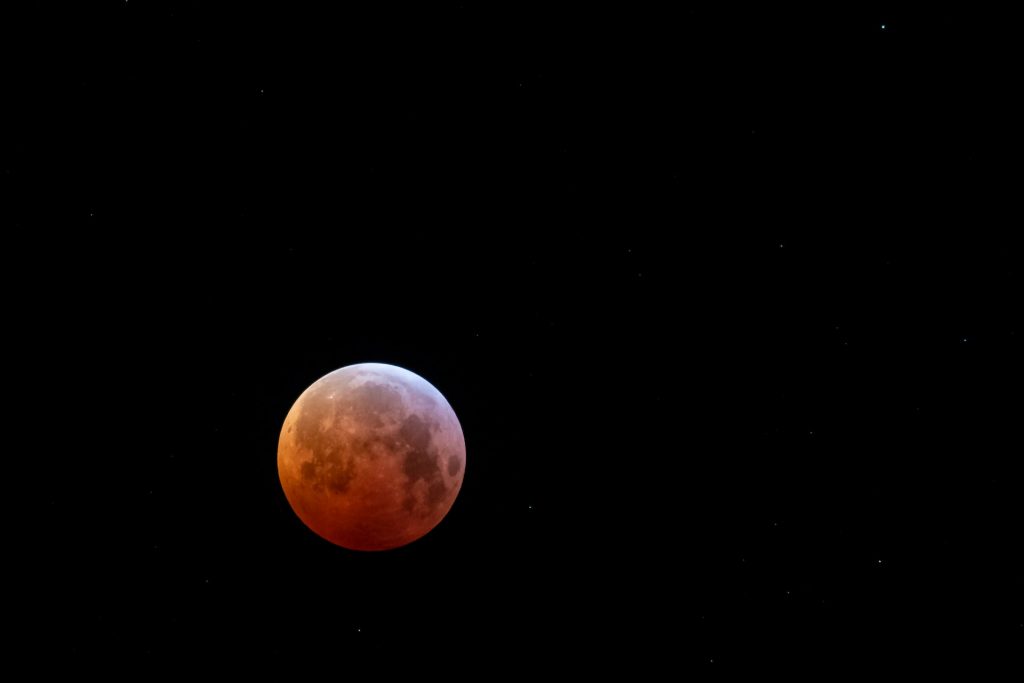 An image of a red blood moon on a black background. No visual metaphor, just looks cool.
